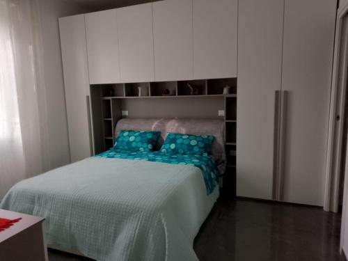 a bedroom with a bed with blue pillows on it at Appartamento Loreto-Fiera in Cremona