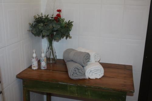 einen Tisch mit Handtüchern und eine Vase Blumen in der Unterkunft Dorpsplasie - Piketberg in Piketberg
