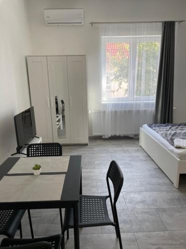a living room with a bed and a table and chairs at Kiss Vendégház 2-3 in Kaposvár