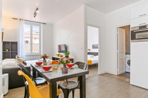 une cuisine et un salon avec une table et des chaises dans l'établissement Appartement Amarilla - Welkeys, à Biarritz