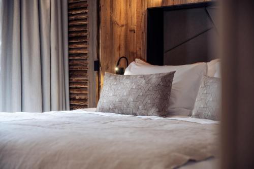 - un lit avec des draps et des oreillers blancs à côté d'une fenêtre dans l'établissement Antarès URSA 001 - luxury apartment ski inski out, à Méribel