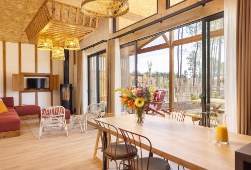 a living room with a large wooden table and chairs at Center Parcs Les Landes de Gascogne in Beauziac