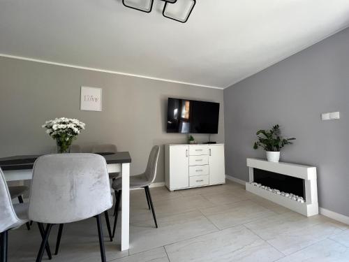 a dining room with a table and a tv at Apartamenty River in Wisła