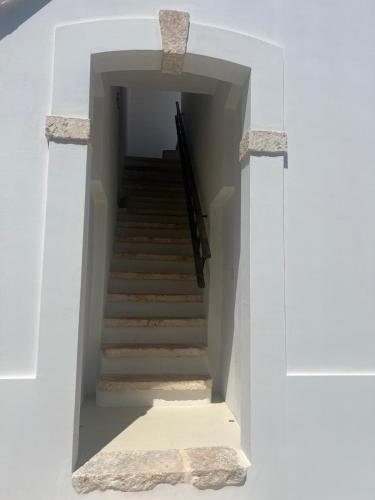 a staircase in a white building with a stair case at Dimora NONNA CATERINA in Monopoli
