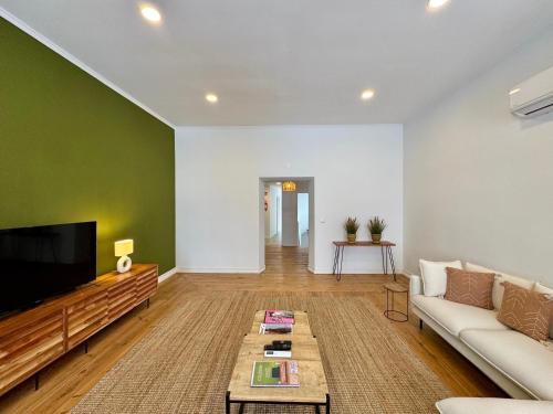 a living room with a couch and a tv at CICIOSO flats João de Deus 2 in Évora