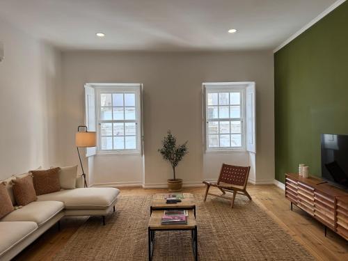 a living room with a couch and a tv at CICIOSO flats João de Deus 2 in Évora