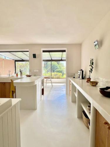 une grande cuisine avec des comptoirs blancs et une grande fenêtre dans l'établissement Villa Bopénian - 400m plage & centre-ville Bandol, à Bandol