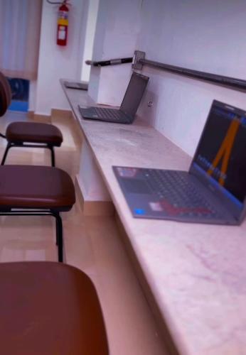 three laptops sitting on a counter in a room at ABA Hotel in Belém