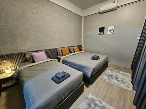 a room with two beds and a couch at K Siri House Hatyai in Hat Yai