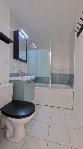 une salle de bain avec toilettes, lavabo et baignoire dans l'établissement Jolie maison 5 minutes de l ocean, à Saint-Hilaire-de-Riez