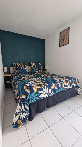 une chambre avec un grand lit avec un mur bleu dans l'établissement Jolie maison 5 minutes de l ocean, à Saint-Hilaire-de-Riez