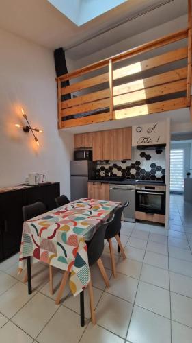 une cuisine avec une table et une cuisinière dans l'établissement Jolie maison 5 minutes de l ocean, à Saint-Hilaire-de-Riez