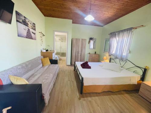 a bedroom with a bed and a couch in it at Fergani Apartments in Moúdhros