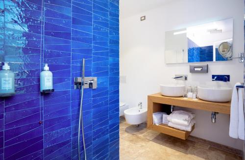 a bathroom with two sinks and a glass shower at Hotel Cala Caterina in Villasimius
