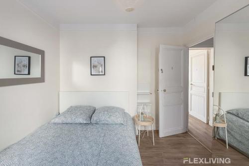 - une chambre blanche avec 2 lits et un miroir dans l'établissement Flexliving - whole apartment - Monge, à Paris