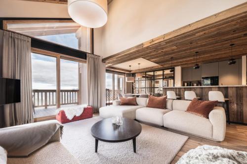 un salon avec un canapé et une table dans l'établissement Antarès MIRA 202 - Pretigious rooftop apartment ski inski out, à Méribel