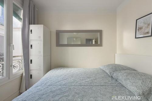 une chambre avec un lit, une commode et un miroir dans l'établissement Flexliving - private bedroom - Monge, à Paris