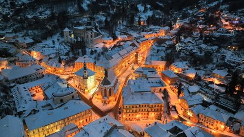 an aerial view of a building with snow covered roofs at night at Apartmány MÚDRA SOVA in Banská Štiavnica