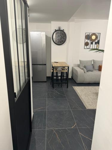 - un salon avec un réfrigérateur et une table dans l'établissement Le Dunkerquois centre ville et plage, à Dunkerque