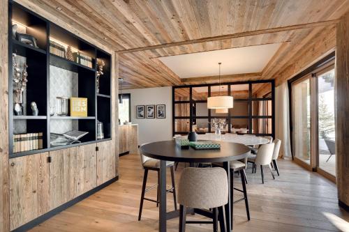 une salle à manger avec une table et des chaises dans l'établissement Antarès NAOS 203D - huge duplex luxury apartment ski inski out, à Méribel