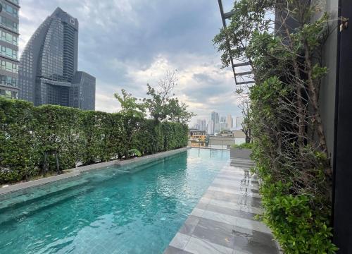une piscine avec des plantes vertes sur un bâtiment dans l'établissement Luxury condo right next to BTS Thonglor!, à Bangkok