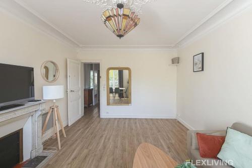 - un salon avec une télévision et un miroir dans l'établissement Flexliving - private bedroom - Monge, à Paris