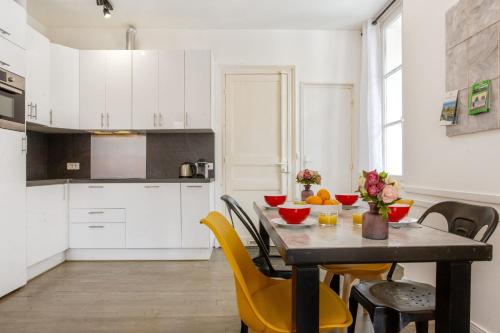 une cuisine avec une table et des chaises jaunes dans une pièce dans l'établissement Appartement Amarilla - Welkeys, à Biarritz