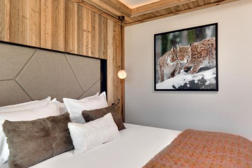 une chambre avec un lit avec un tableau sur le mur dans l'établissement Antares STELLA 002 - Ski inski out apartment, à Méribel