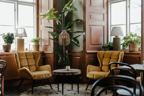 two chairs and a table in a room with plants at Haga Slott in Enköping