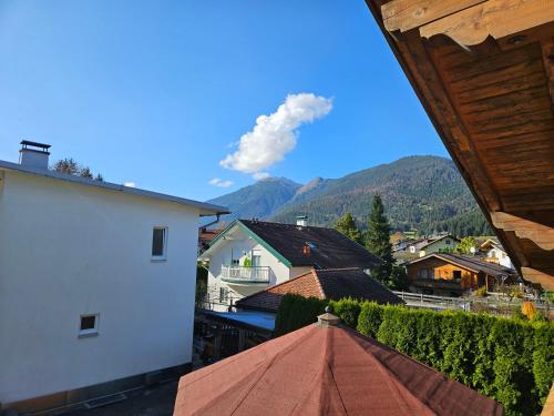 a view of a town from a balcony with an umbrella at Haus Gaichtspitzblick in Weissenbach am Lech