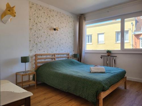 une chambre avec un grand lit et une fenêtre dans l'établissement Appart Cosy parking privé Croisé Laroche près tram, à Marcq-en-Barœul