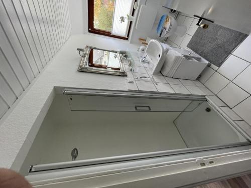 encimera con fregadero y espejo en Ferienwohnung Alice, en Burhave