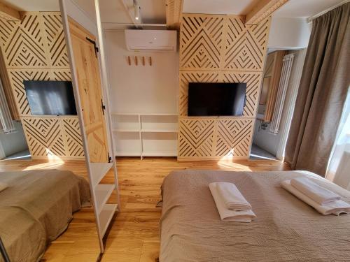 a bedroom with two beds and a mirror and a tv at Willa Storczyk Asnyka Centrum in Zakopane