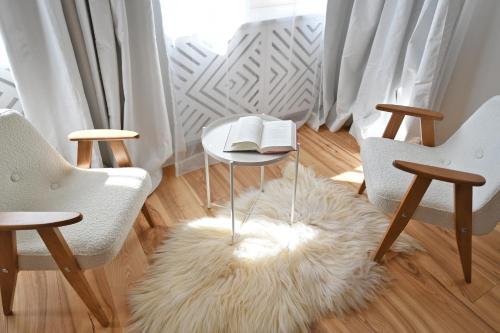 a room with two chairs and a table with a book on it at Willa Storczyk Asnyka Centrum in Zakopane