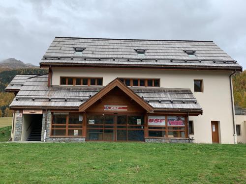 a large white building with a gambrel roof at Appartement duplex pied des pistes et parking couvert in Arvieux
