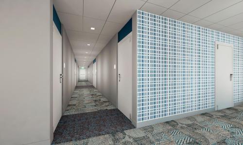 a corridor of a hallway with blue tiles on the wall at Microtel Inn & Suites by Wyndham Prattville Montgomery in Prattville