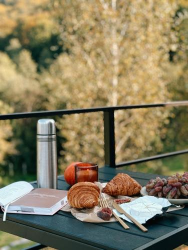 a table with croissants and other foods on it at Dobrede - будиночки під лісом in Dubrynychi