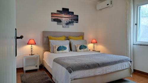 une chambre avec un grand lit avec deux lampes dans l'établissement Typical Madeira Orchid House, à Calheta