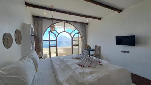 a bedroom with a large bed with a large window at The Kayuan in Kintamani