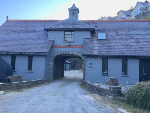 an old house with an archway and a building at Beautiful Pendine Manor House in West Wales in Pendine