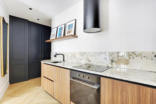 une cuisine avec un évier et un comptoir dans l'établissement Pick A Flat's Apartment in Triangle d'Or - Pierre 1er de Serbie, à Paris