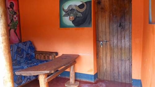 a wooden bench sitting in front of a room with a door at Blue Star Homestay in Kapchorwa