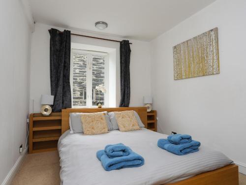 a bedroom with a bed with blue towels on it at The Old Cornhill in Porthmadog