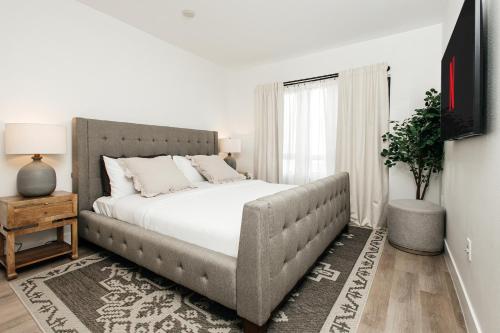 a bedroom with a large bed with white sheets at Central Quality 2 BD Apartment in Los Angeles