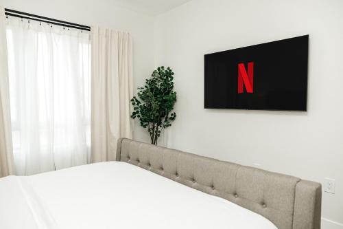 a white bedroom with a bed with avertisementatronatronstrationstration at Central Quality 2 BD Apartment in Los Angeles