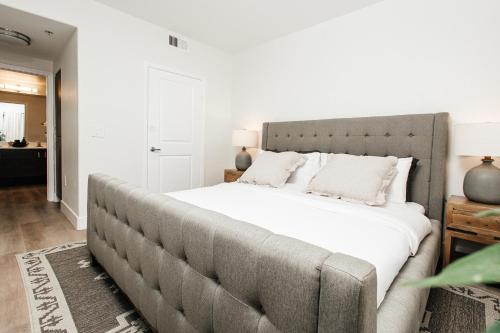a bedroom with a large bed with white sheets at Central Quality 2 BD Apartment in Los Angeles