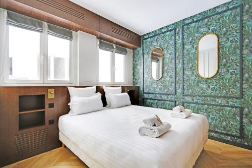 une chambre avec un grand lit avec deux serviettes dessus dans l'établissement Pick A Flat's Apartment in Triangle d'Or - Pierre 1er de Serbie, à Paris