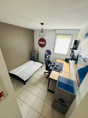 une petite chambre avec un lit et un bureau dans l'établissement Appartement, à Millau