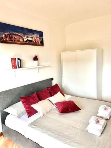 a bedroom with a bed with red and white pillows at Appartamento Roma Est in Lunghezza