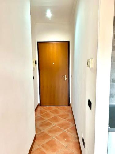 a hallway with a brown door and a tile floor at Appartamento Roma Est in Lunghezza